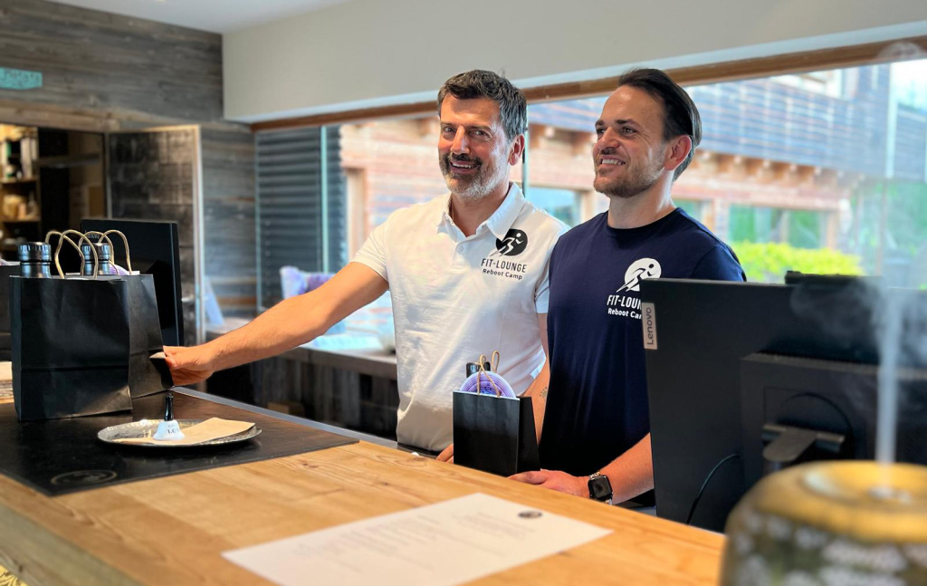 Zwei Männer im Fit-Lounge Reboot Camp am Empfangstresen